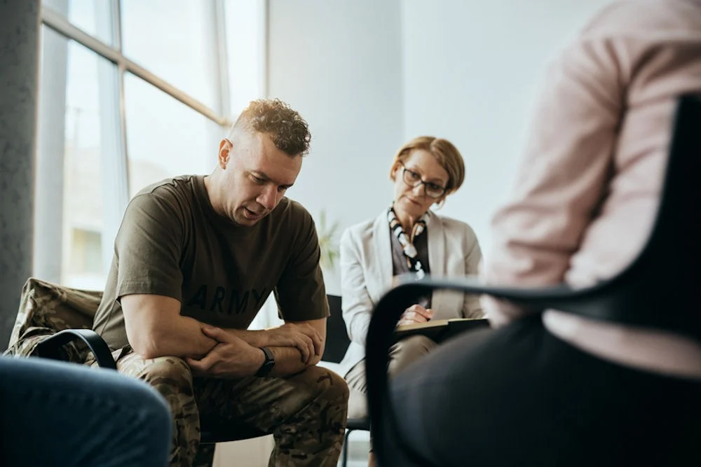 depression-treatment-program Depressed military man talks during group therapy meeting at mental health center.
