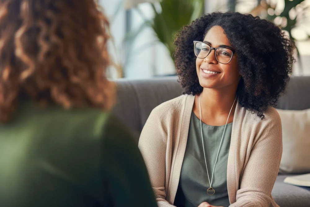 addiction-aftercare Female therapist smiling warmly at a patient during consultation, showing compassionate care in neuropsychological testing and evaluation.