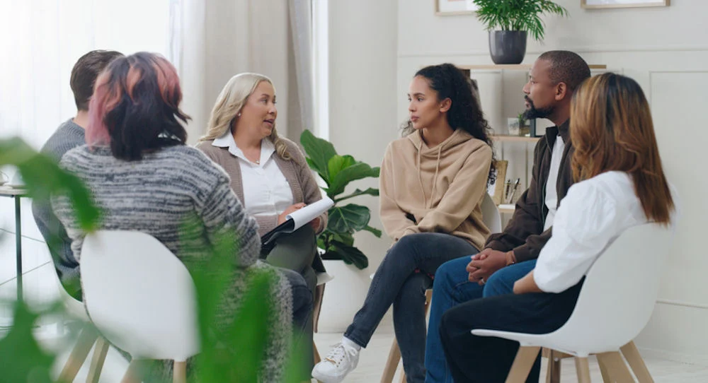 People participating in a group therapy session People participating in a group therapy session
