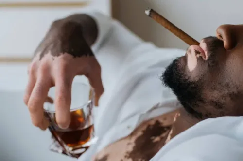 An individual smoking while drinking alcohol